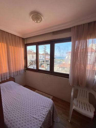 a bedroom with a bed and a large window at 2 minute walk to seaside in Kuşadası