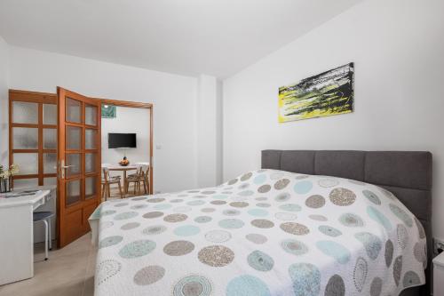 a bedroom with a bed and a desk and a kitchen at Apartments Vilma in Opatija