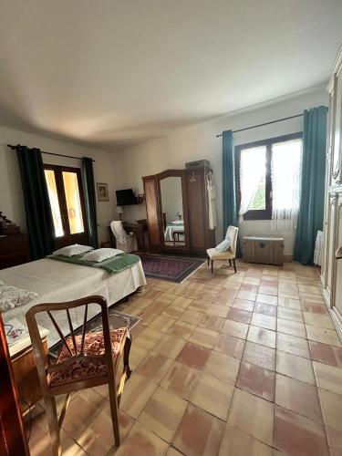 a bedroom with a bed and a chair and a mirror at La finestra sul limone in Castelvetrano Selinunte