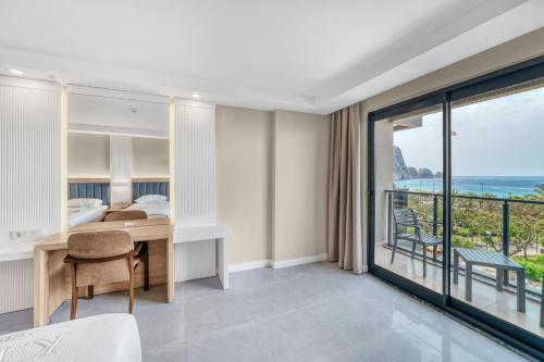 a bedroom with a desk and a view of the ocean at Kahya Hotel in Alanya