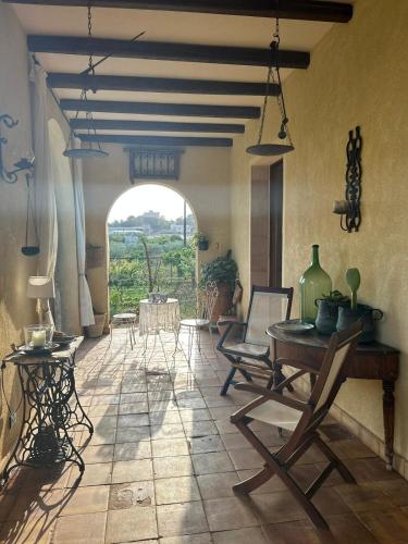 a living room with a table and chairs and a window at La finestra sul limone in Castelvetrano Selinunte