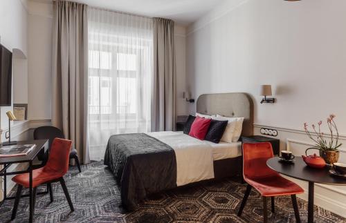 una stanza d'albergo con un letto, un tavolo e delle sedie di N33 Premium Apartments Old Town Kraków - Destigo Hotels a Cracovia