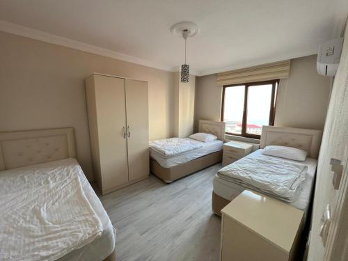 Habitación pequeña con 2 camas y ventana en TRABZON aparts, en Cimenli