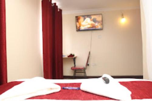 een slaapkamer met een bed met een rode deken en een stoel bij Machakos Inn Hotel in Machakos
