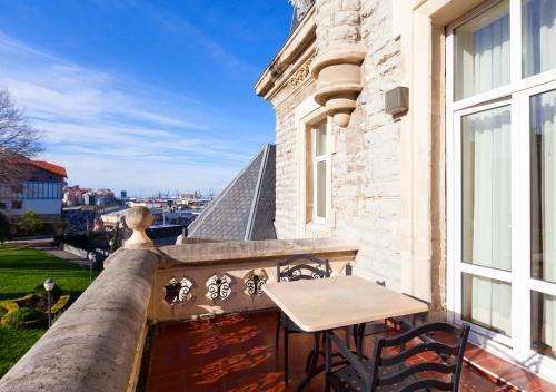 a balcony with a table and chairs on a building at Hotel URH Palacio de Oriol in Santurce