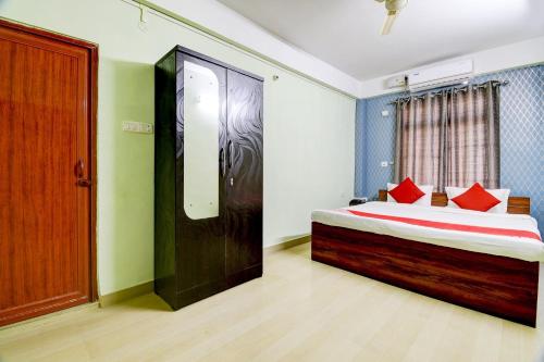 a bedroom with a bed with red pillows at Hotel O The Dove Villa in Dispur