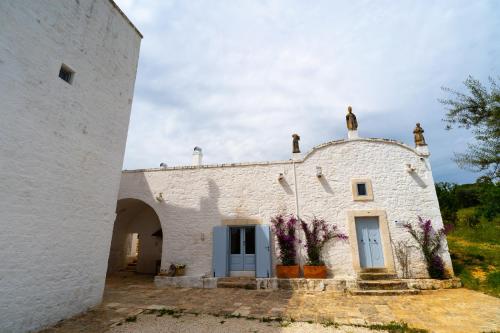 a white building with purple flowers on it at Masseria Soluco in Monopoli
