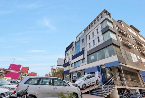 a building with cars parked in a parking lot at Hotel Rudra Grand Near Kondapur x Road in Kondapur
