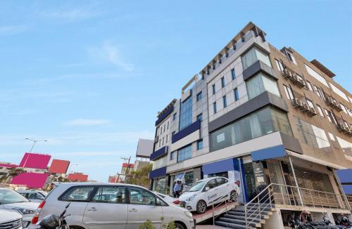 un bâtiment avec des voitures garées dans un parking dans l'établissement Hotel Rudra Grand Near Kondapur x Road, à Kondapur