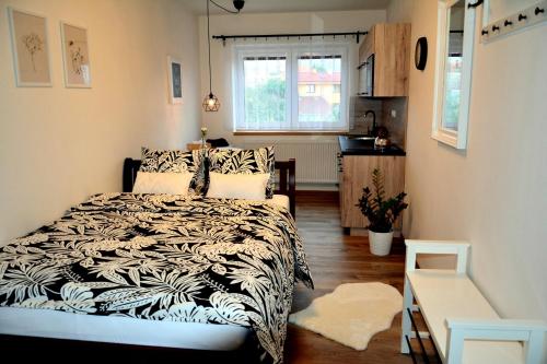 ein Schlafzimmer mit einem Bett mit einer schwarzen und weißen Decke in der Unterkunft Apartmány u Kotačků in Veverské Knínice