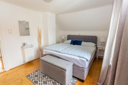 ein kleines Schlafzimmer mit einem Bett und einem Stuhl in der Unterkunft Haus Roserlheim in Pörtschach am Wörthersee
