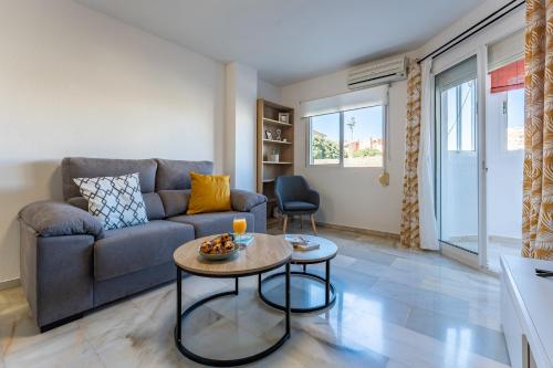 ein Wohnzimmer mit einem Sofa und einem Tisch in der Unterkunft CT 245 - Faro's Arroyo de la Miel Apartment - Cuddly Nest for 2 in Arroyo de la Miel