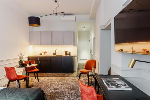 クラクフにあるN33 Premium Apartments Old Town Kraków - Destigo Hotelsのテーブルと椅子、キッチンのあるリビングルーム