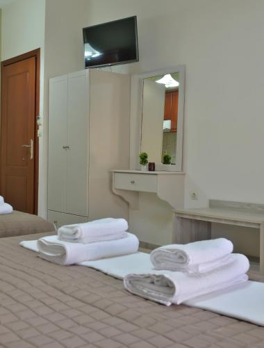 a group of towels sitting on a bed with a mirror at Harikleia Studios in Leptokarya