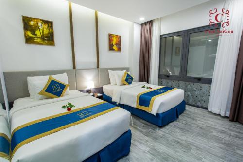 a hotel room with two beds and a window at Ciao Saigon 2 Hotel in Ho Chi Minh City