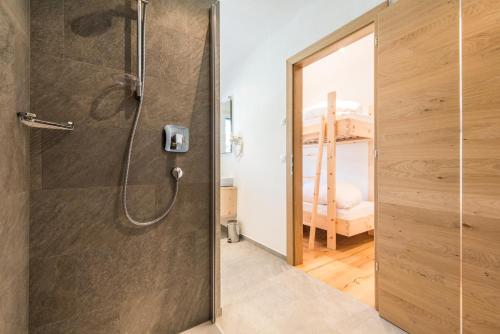 アンテルセルヴァ・ディ・メッツォにあるHotel Antholzerhofのバスルーム(ガラスドア付きのシャワー付)