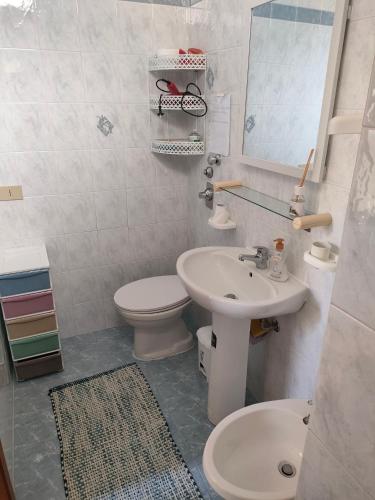 a bathroom with a sink and a toilet and a mirror at Marilù Home in Trapani