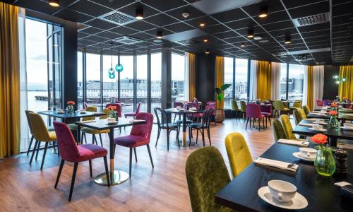 a restaurant with tables and chairs and windows at Thon Hotel Ålesund in Ålesund