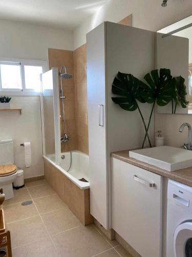 a bathroom with a sink and a toilet and a plant at Ed. Senses. Apartamento Happiness in Tarifa