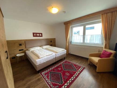 シャルニッツにあるHaus Waldheim und Dependanceのベッドルーム1室(ベッド1台、椅子、窓付)