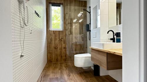 a bathroom with a toilet and a sink and a shower at Apartamenty Karkonoska Polana in Staniszów
