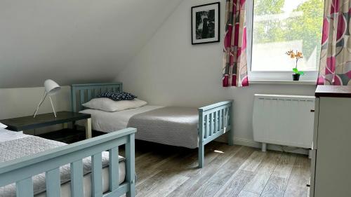 a small bedroom with two beds and a window at Apartamenty Karkonoska Polana in Staniszów