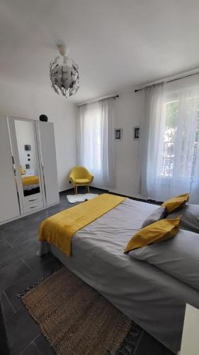 a bedroom with a large bed and a yellow chair at Le cœur de Marseille 2 in Marseille