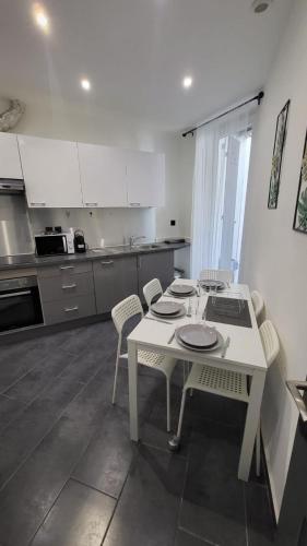 a kitchen with a white table and chairs in it at Le cœur de Marseille 2 in Marseille