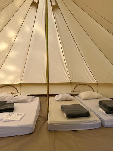 two mattresses in a canvas tent with two beds at Camping de Messeugne 