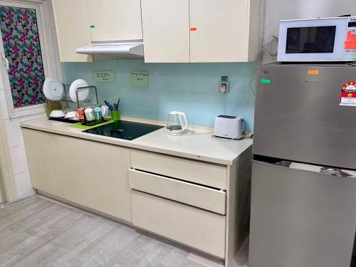 a kitchen with a sink and a refrigerator at ARH Home KLCC in Kuala Lumpur