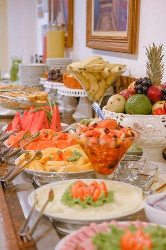 a buffet with many plates of food on a table at Profissionalle Hotel São Luís in São Luís