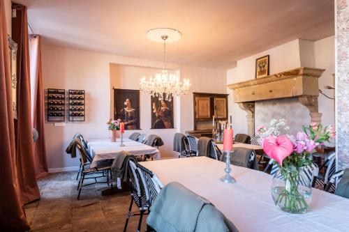 un restaurant avec des tables et des chaises et une cheminée dans l'établissement Chateau Melay, à Melay