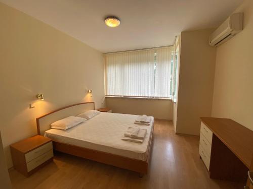 a small bedroom with a bed and a window at GT Sunny Fort Apartments in Sunny Beach