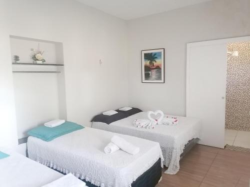 2 łóżka w pokoju z białymi ścianami w obiekcie HOTEL FAZENDA Engenho Velho w mieście Ubajara
