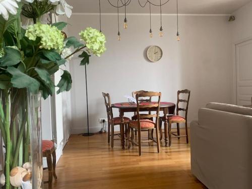 武夫賴的住宿－Maison classée 3 étoiles à Vouvray Loire Valley，餐桌、椅子和墙上的时钟