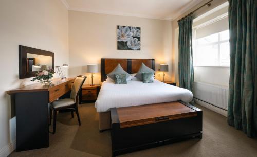 a hotel room with a bed and a desk and a desk at Castle Hotel Macroom in Macroom