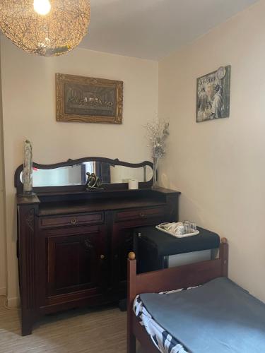 Cette chambre comprend une coiffeuse, un miroir et un lit. dans l'établissement Maison 4 km Disneyland 30 min Paris, à Esbly