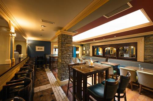 a bar with tables and chairs in a restaurant at Castle Hotel Macroom in Macroom
