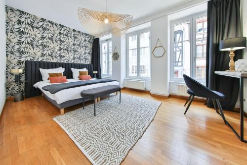 ein Schlafzimmer mit einem Bett und einem Teppich in der Unterkunft ColmarAppart Vauban avec Spa in Colmar