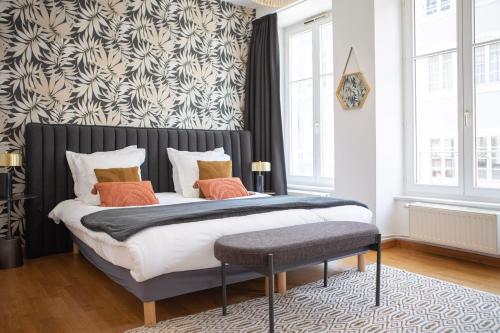sypialnia z dużym łóżkiem z pomarańczowymi poduszkami w obiekcie ColmarAppart Vauban avec Spa w mieście Colmar