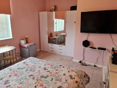 a bedroom with a bed and a flat screen tv at KELVIN HOUSE in Durham