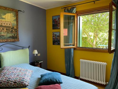 a bedroom with a bed and a window at LunaSole Casa vacanza mare in Aprilia Marittima