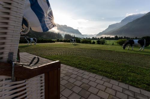 a mural of cows in a field with mountains in the background at KUHOTEL by Rilano in Waidring