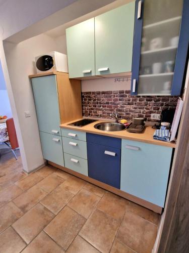 a kitchen with blue cabinets and a sink at Apartments Karin in Bled