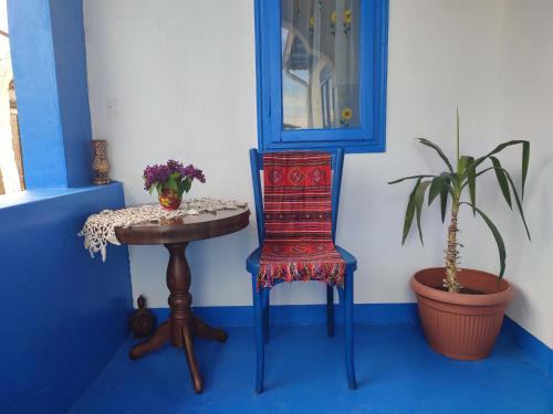 Camera blu e bianca con tavolo e sedia di Casa Traditionala Clisciova a Murighiol