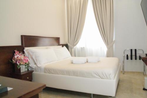 a bedroom with a bed with white sheets and a window at Esposizione Boutique in Rome