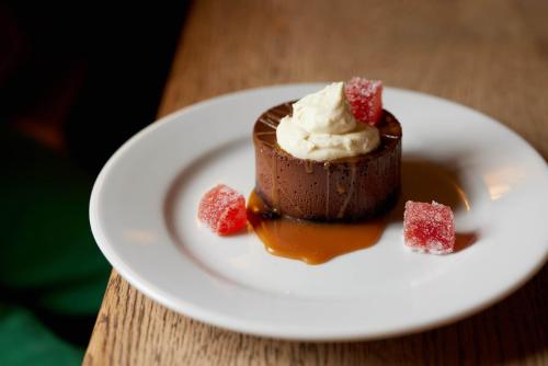 a chocolate dessert on a white plate on a table at The Queen's Head in Broad Chalke