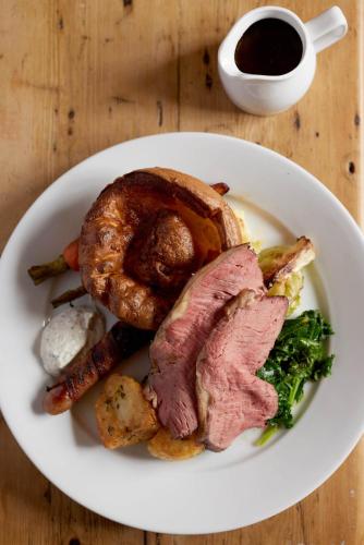 a plate of food with meat and vegetables on a table at The Queen's Head in Broad Chalke