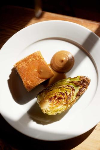 a white plate with food on a table at The Queen's Head in Broad Chalke