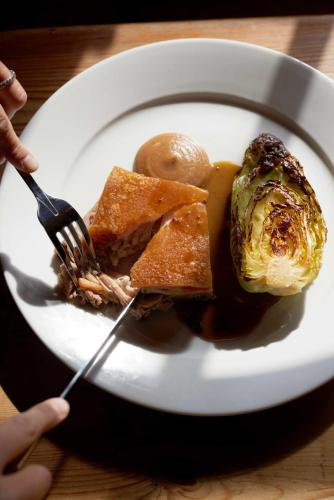 a person holding a fork and a plate of food at The Queen's Head in Broad Chalke